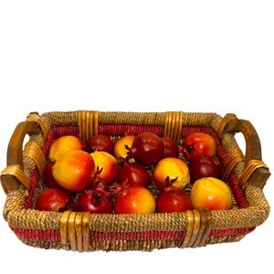 Bright and cheerful handwoven basket with wooden handles and artificial fruit